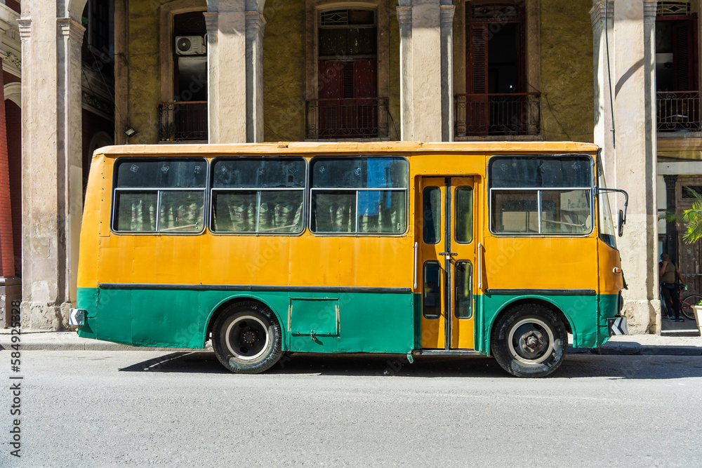 Old Yellow And Green Bus Parked In Front Of A Building. Old Yellow And Green Bus Parked In Front Of A Building.
