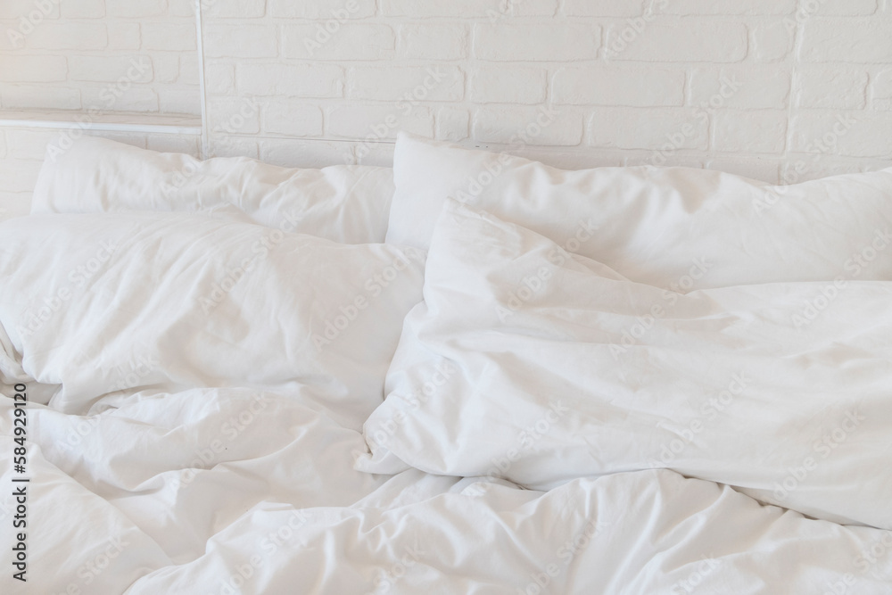 © Sonja Lekovic/Stocksy - white bed sheets and pillows and white brick wall