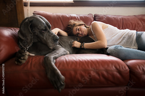 Teenage tenderly caressing big dog on the sofa photo