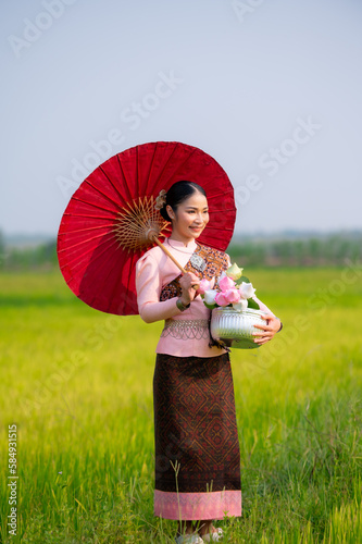 Pretty Asian women in traditional Thai dress. Beautiful traditional Thai dresses by Asian Buddhists make merit at the Temple a tourist attraction, a