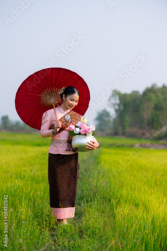 Pretty Asian women in traditional Thai dress. Beautiful traditional Thai dresses by Asian Buddhists make merit at the Temple a tourist attraction, a