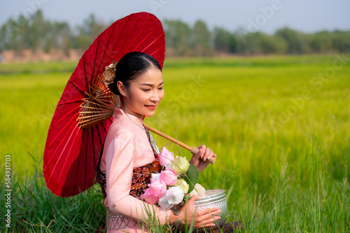 Pretty Asian women in traditional Thai dress. Beautiful traditional Thai dresses by Asian Buddhists make merit at the Temple a tourist attraction, a
