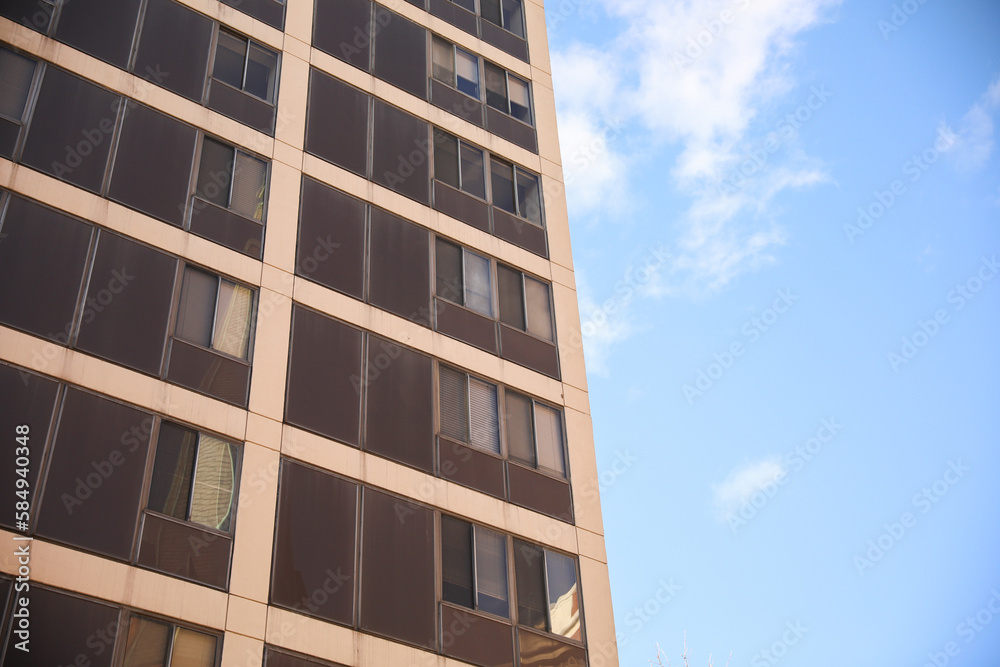 A sleek and modern building exterior with clean lines and large windows that reflect the blue sky. The building features a mix of concrete, steel, and glass, a futuristic and sophisticated look A sleek and modern building exterior with clean lines and large windows that reflect the blue sky. The building features a mix of concrete, steel, and glass, a futuristic and sophisticated look