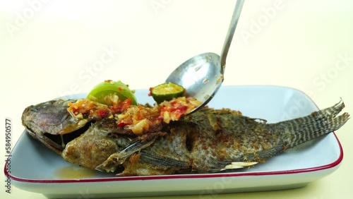 Pecak Ikan Mujair Betawi is a traditional Indonesian dish that originated from Betawi, the native people of Jakarta, Indonesia. Isolated and copy space. photo