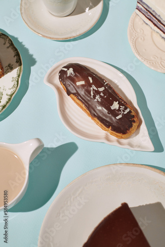 chocolate eclair surrounded by desserts and drinks photo