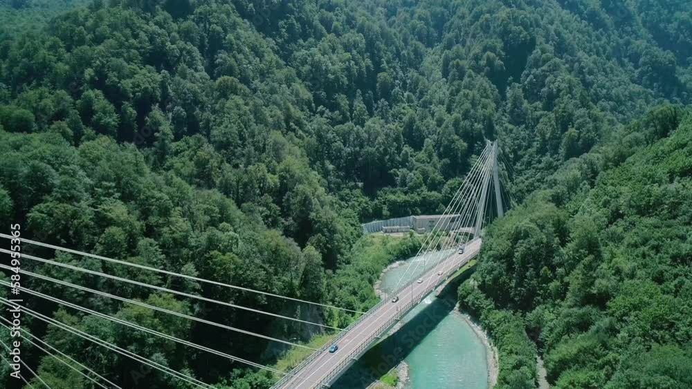 Aerial of a highway in the mountains. An automobile cable-stayed bridge over a mountain river in a gorge. The concept of civil engineering in a mountainous area. Aerial of a highway in the mountains. An automobile cable-stayed bridge over a mountain river in a gorge. The concept of civil engineering in a mountainous area.