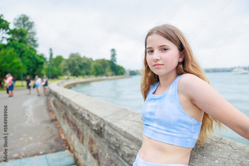 スポーツウエアを着て海岸で休憩する白人少女