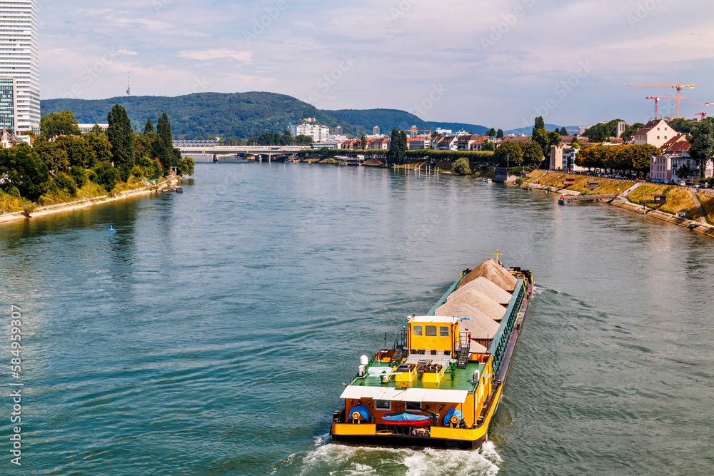 Self propelled barge carrying construction material in River Rhine, Basel, Switzerland
