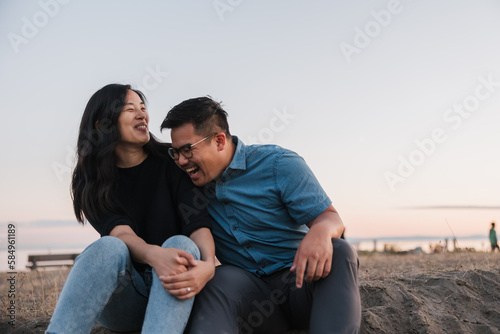 Relaxed romantic partners sitting outside on sand in the evening photo