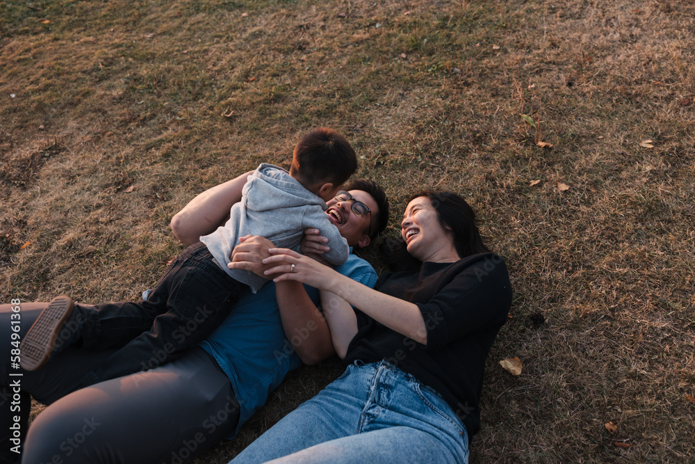 Family of three enjoying time together outside at sunset. Family of three enjoying time together outside at sunset.