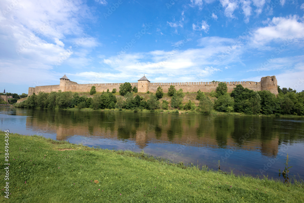 View of the Russian ancient Ivangorod fortress from the Estonian bank of the Narova river on a sunny August day. Border of Estonia and Russia