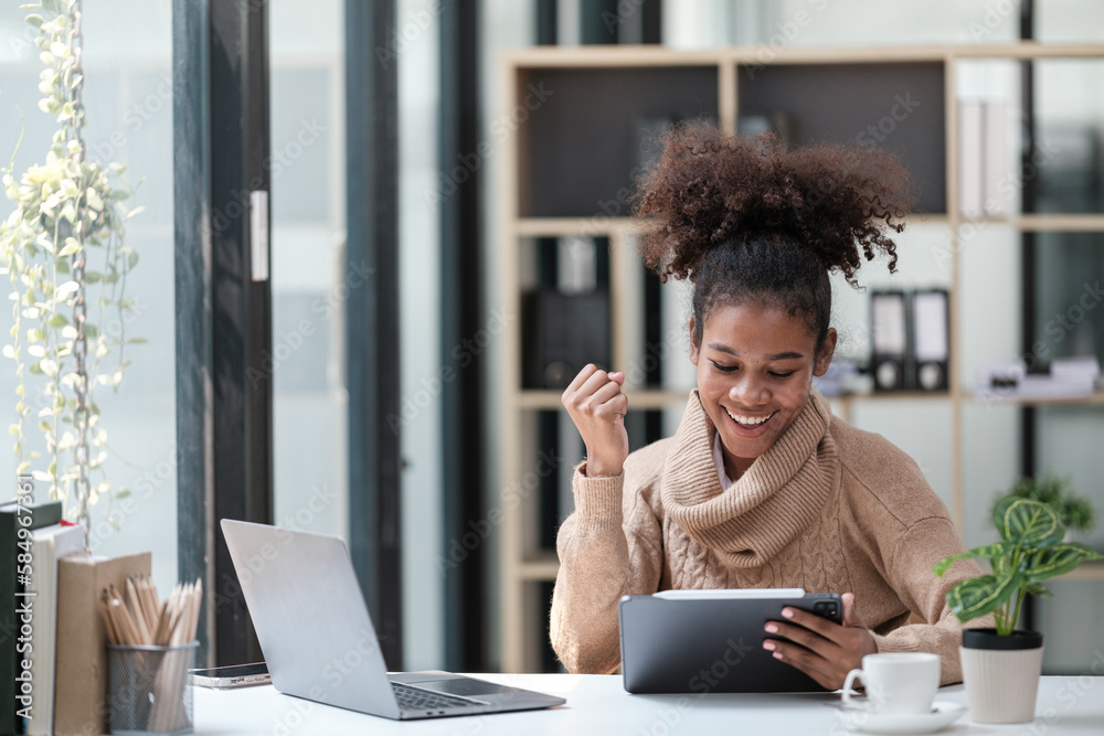 American African Woman working in the office with computer phone and Tablet. American African Woman working in the office with computer phone and Tablet.