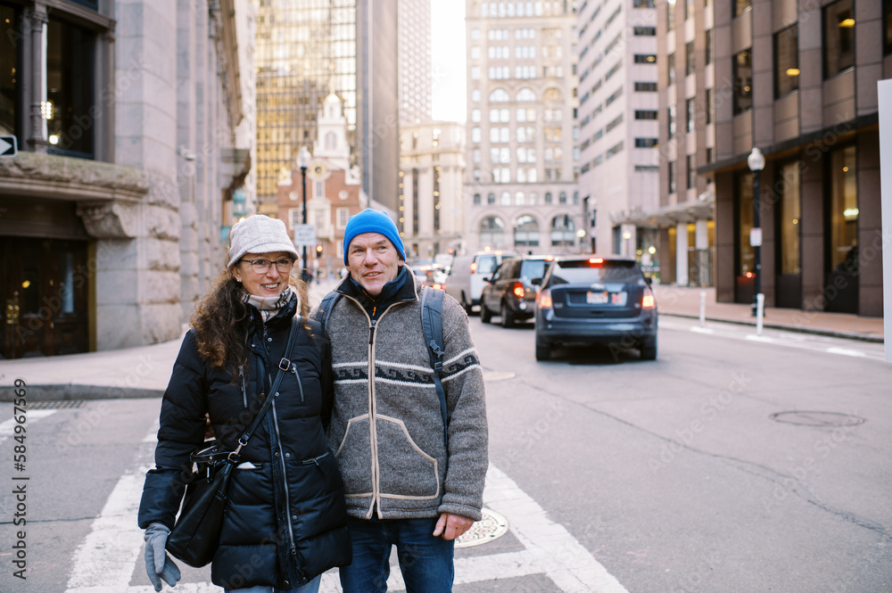 Smiling middle aged couple walking through Boston in winter together Smiling middle aged couple walking through Boston in winter together
