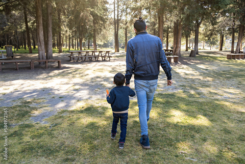 Wide Shot Of Father And His Son Walking Hand In Hand photo