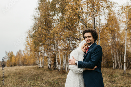 A woman with headscarf leaning on the man shoulder
