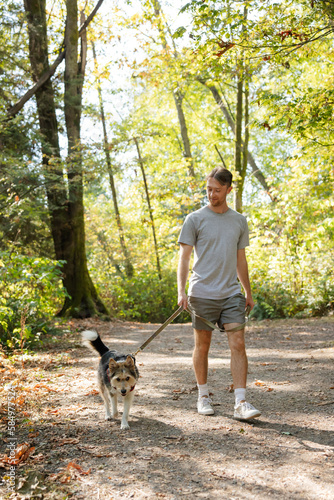 Man enjoying dog walk with wiry pup.
