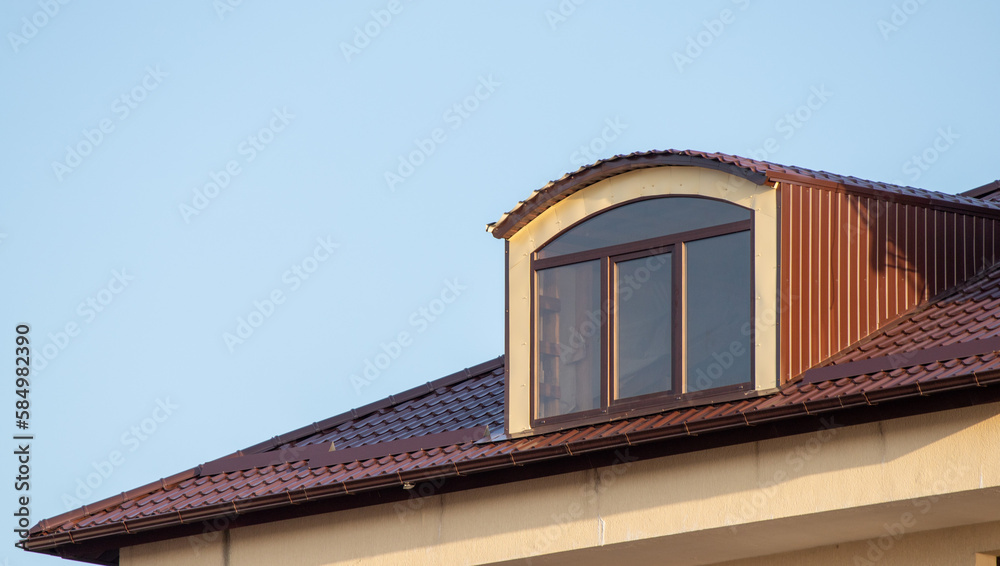 Roofs of houses with dormer windows against the sky. Urban architecture.