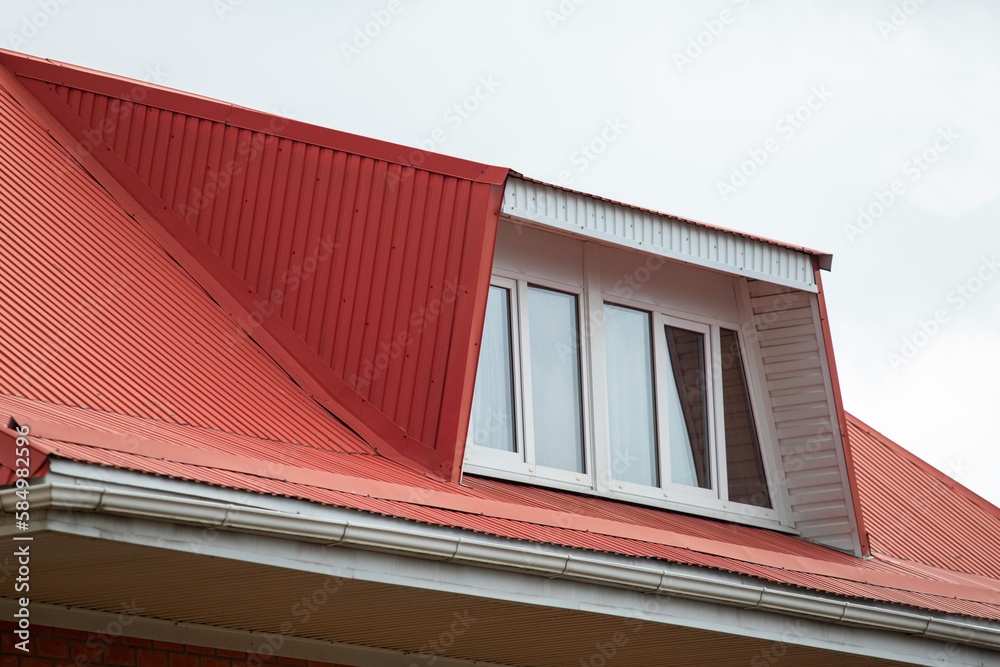 Roofs of houses with dormer windows against the sky. Urban architecture.