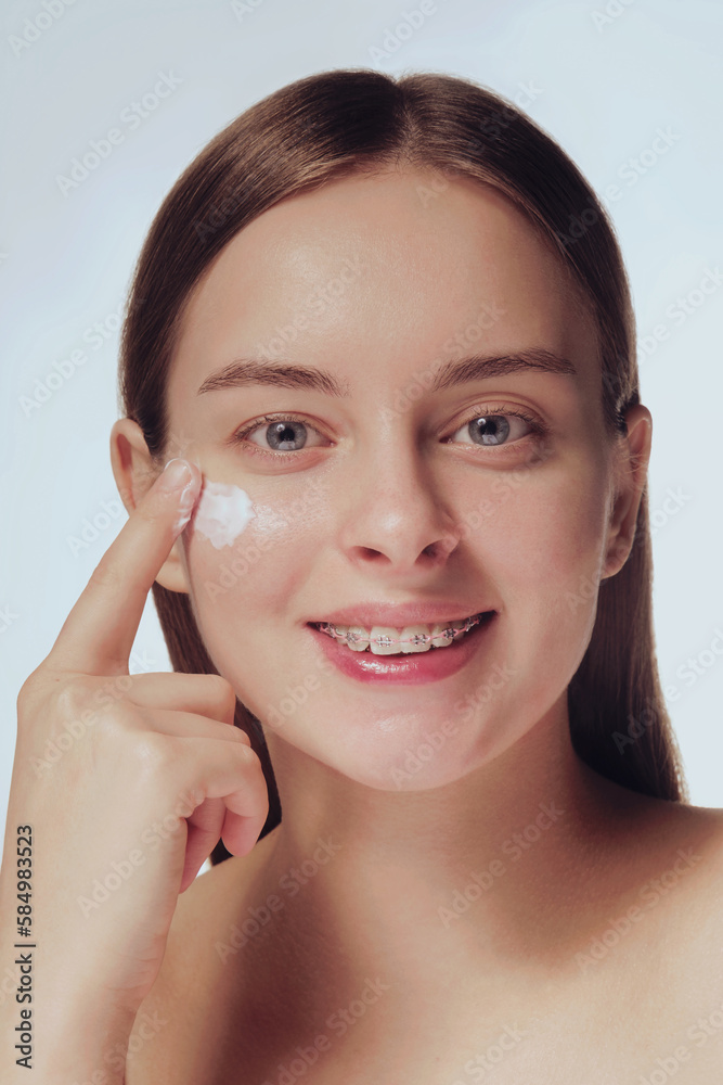 Model with clean fresh skin, glowing, hydrated, apply skin cream