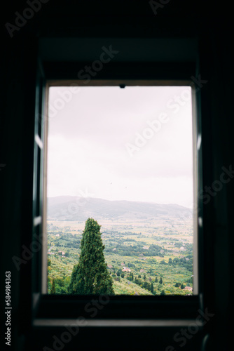 view through the window on the field and mountains of italy