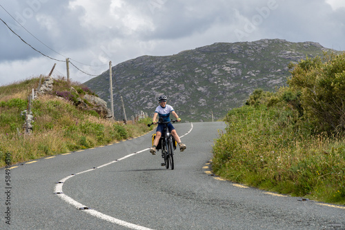 Fototapeta Naklejka Na Ścianę i Meble -  Young female traveler cyclist smiling on Connemara route