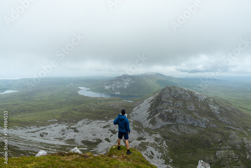 Man standing on top of mountain admiring landscape of Errigal mountain © Cavan