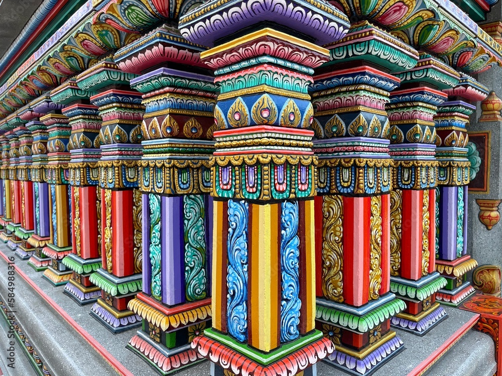 Traditional Indian style architecture. Corner of fence of Hindu temple, Bangkok, Thailand. Sri Maha Mariamman Temple. Brightly colored pillars of fence bordering the territory of religious complex.