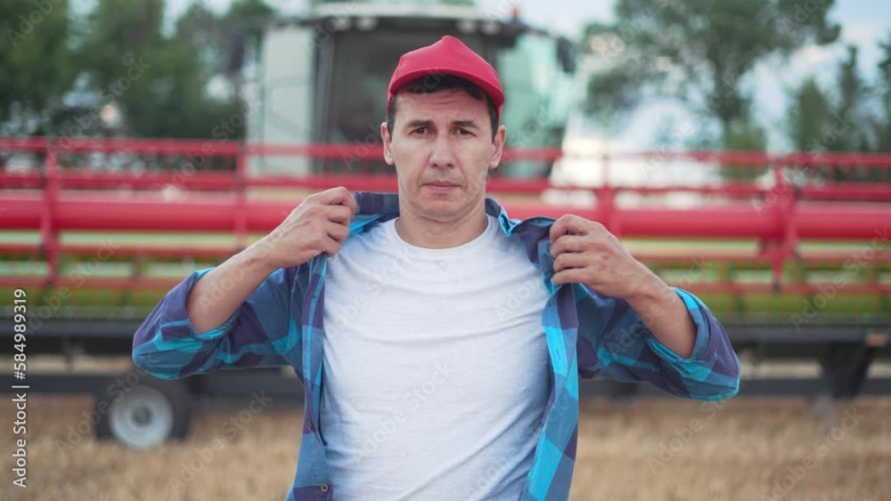 Agriculture concept. Farmer with tablet controls harvest. Harvester in a wheat field. Agronomist worker checks quality of crop. Farm business in the countryside. Restricted products on fertile soil. Agriculture concept. Farmer with tablet controls harvest. Harvester in a wheat field. Agronomist worker checks quality of crop. Farm business in the countryside. Restricted products on fertile soil.