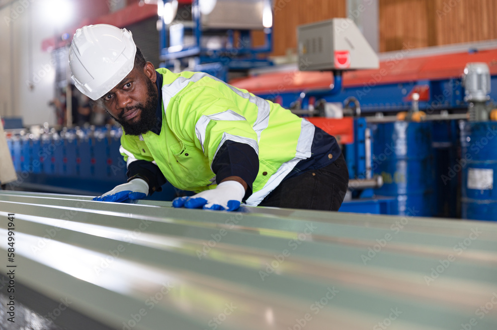 Portrait African American engineer man checking metal at metal sheet factory Portrait African American engineer man checking metal at metal sheet factory