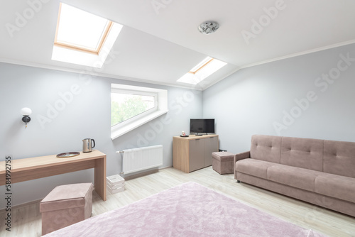 Hotel room with a large double bed in light colors