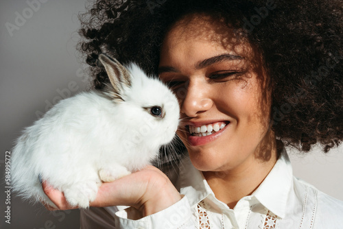 Beautiful laughing woman with rabbit in hand. photo