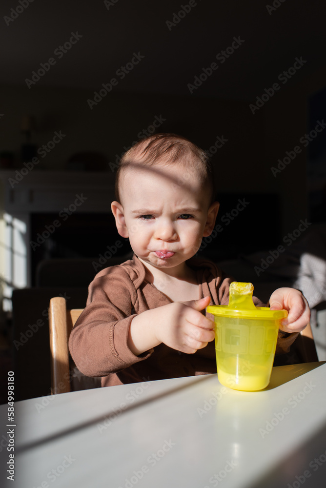 Toddler Makes Funny Face While Drinking Milk from Sippy Cup Toddler Makes Funny Face While Drinking Milk from Sippy Cup