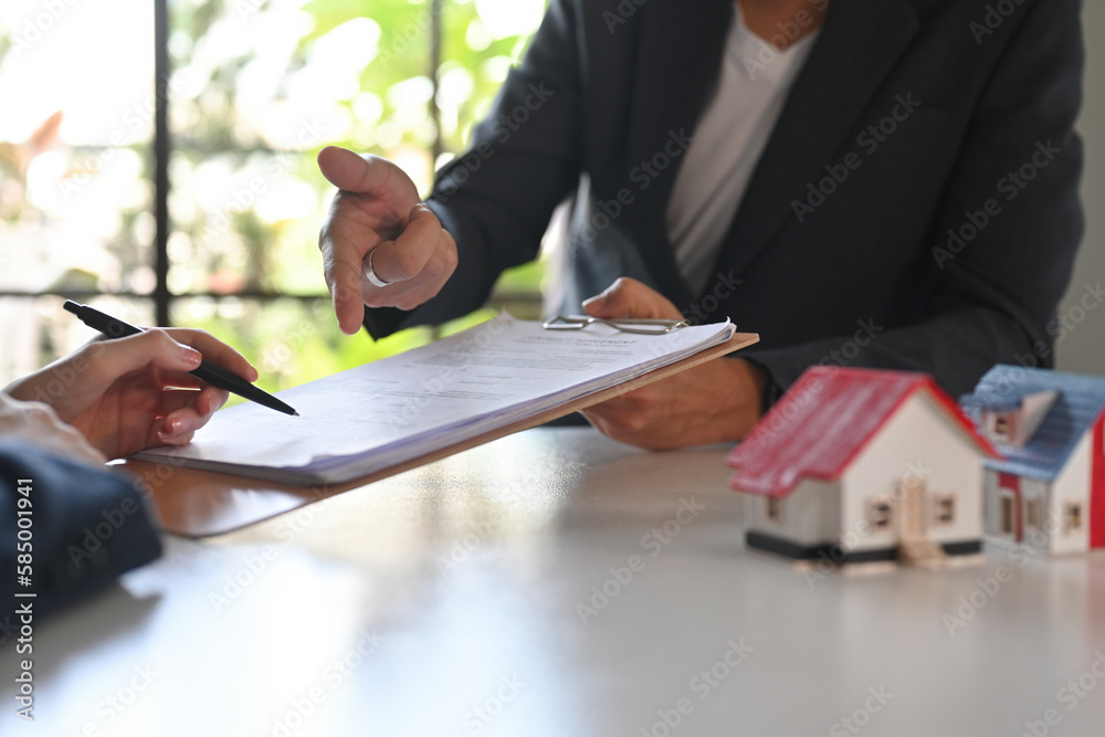 Cropped shot of real estate agent offering home ownership and life insurance client. Real estate, mortgage, loan and property concept.
