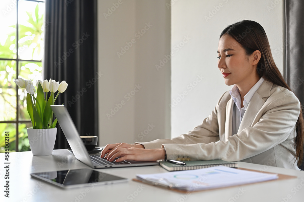 Attractive businesswoman using laptop on white office desk, web surfing information or checking email. Attractive businesswoman using laptop on white office desk, web surfing information or checking email.