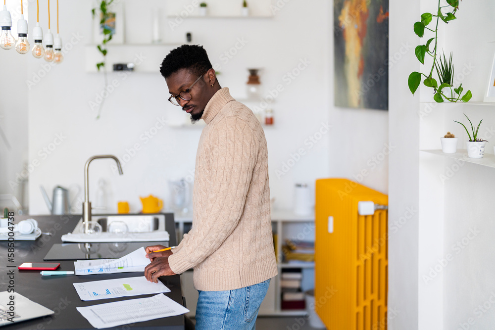 man examining bills in kitchen man examining bills in kitchen