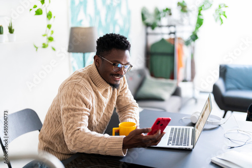 man using smartphone and laptop