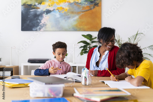 Black mother helping sons with homework