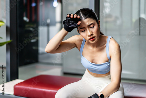 Portrait young asian woman in gym after workout, tired have sweaty and shortness of breath after physical training or exercise to burn energy, build muscle strength on training class in fitness.