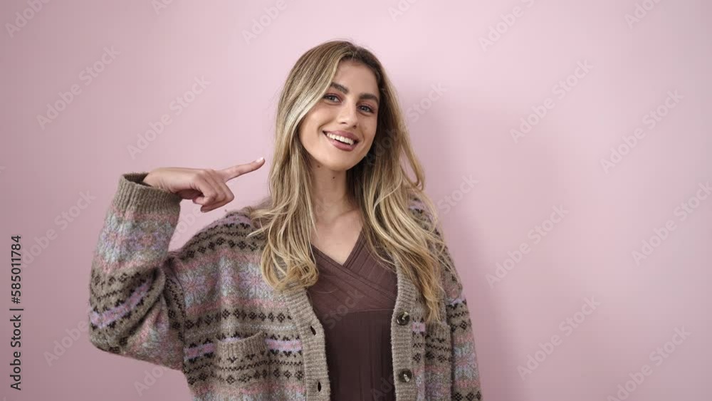 Young blonde woman smiling confident pointing to mouth with finger over isolated pink background Young blonde woman smiling confident pointing to mouth with finger over isolated pink background