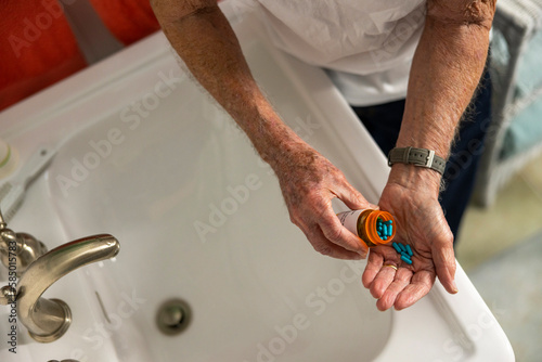 Lone Senior Citizen with prescription pill bottle in hand 