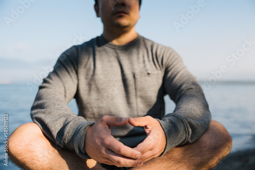 Mindful man meditiating outside on rocks. photo