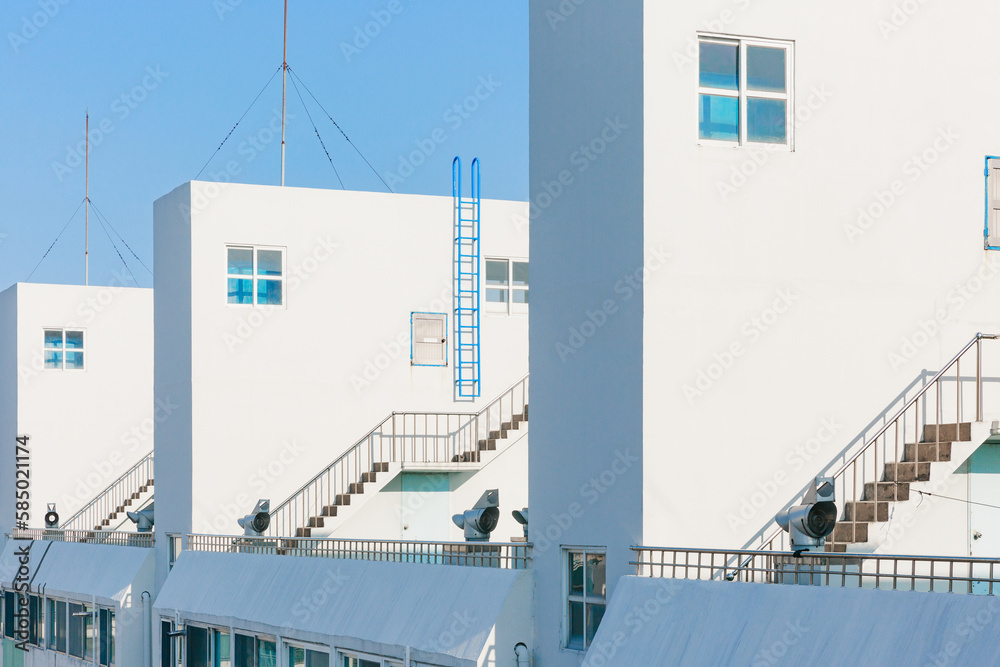 © Jeongho Byeon/Stocksy - Roof top structure of white apartment building.