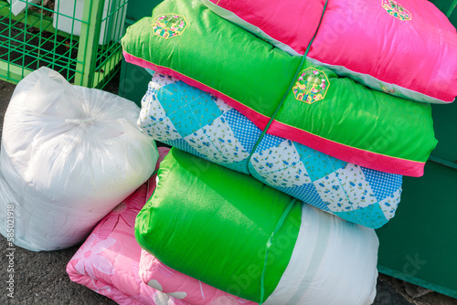 Bundle of colorful quilts discarded at a recycling center. photo