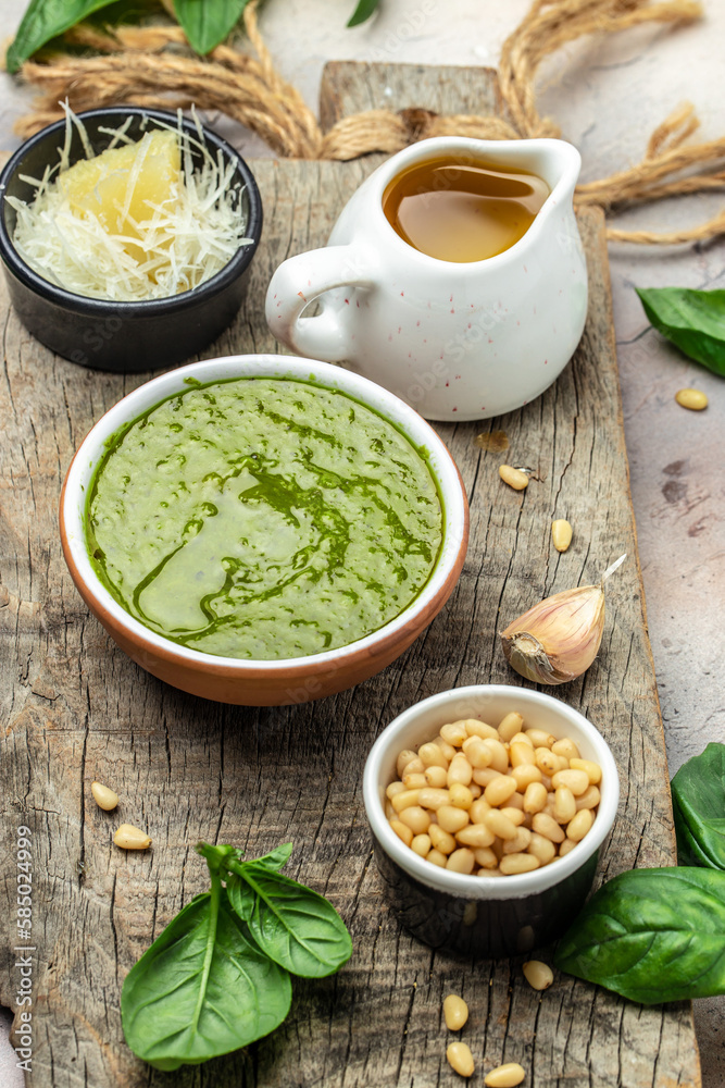 Homemade pesto sauce and ingredients, Traditional Italian pesto recipe for pasta on a dark background, vertical image. top view. place for text Homemade pesto sauce and ingredients, Traditional Italian pesto recipe for pasta on a dark background, vertical image. top view. place for text