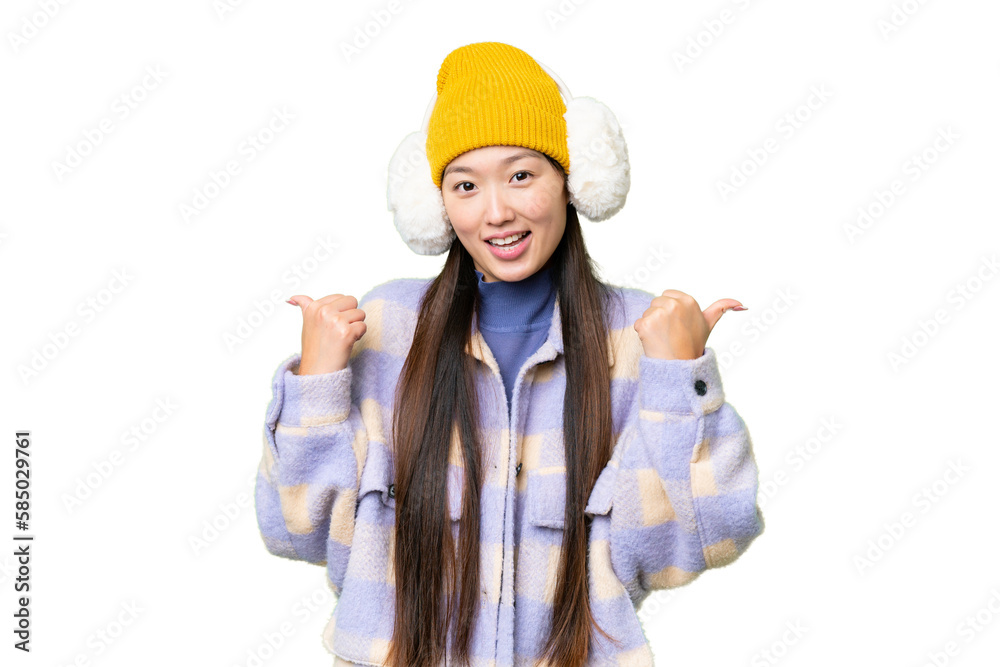 Young Asian woman wearing winter muffs over isolated chroma key background with thumbs up gesture and smiling Young Asian woman wearing winter muffs over isolated chroma key background with thumbs up gesture and smiling