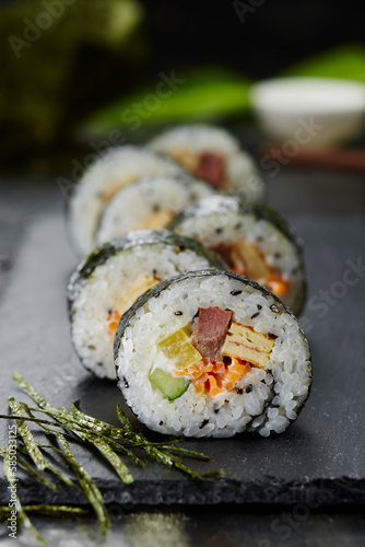 Closeup hand rolled sushi on black slate photo