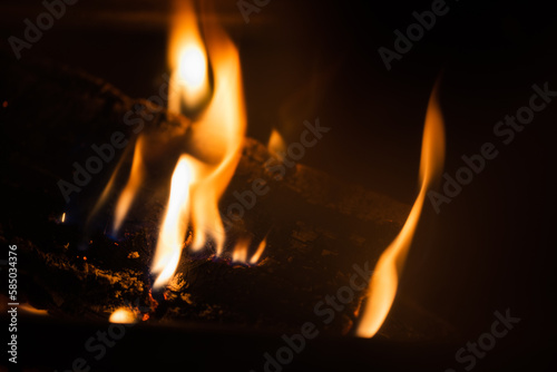 Slow burning fire in a fireplace at night, natural close-up photo