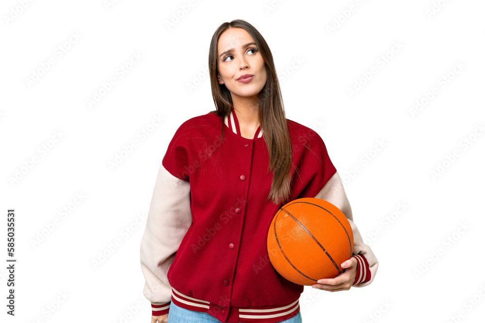 Young beautiful woman playing basketball over isolated chroma key background and looking up