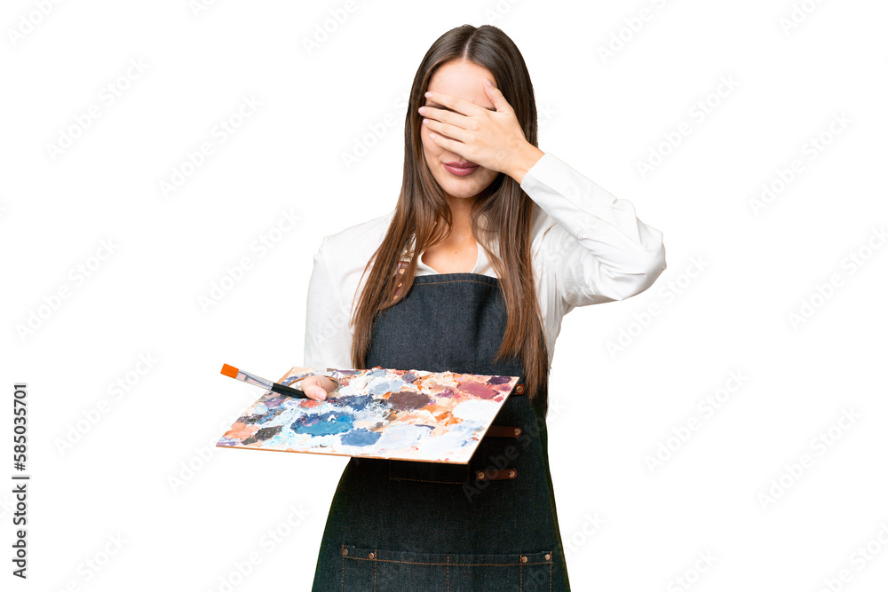 Young artist woman holding a palette over isolated chroma key background covering eyes by hands. Do not want to see something Young artist woman holding a palette over isolated chroma key background covering eyes by hands. Do not want to see something