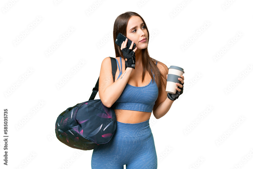Young sport woman with sport bag over isolated chroma key background holding coffee to take away and a mobile Young sport woman with sport bag over isolated chroma key background holding coffee to take away and a mobile